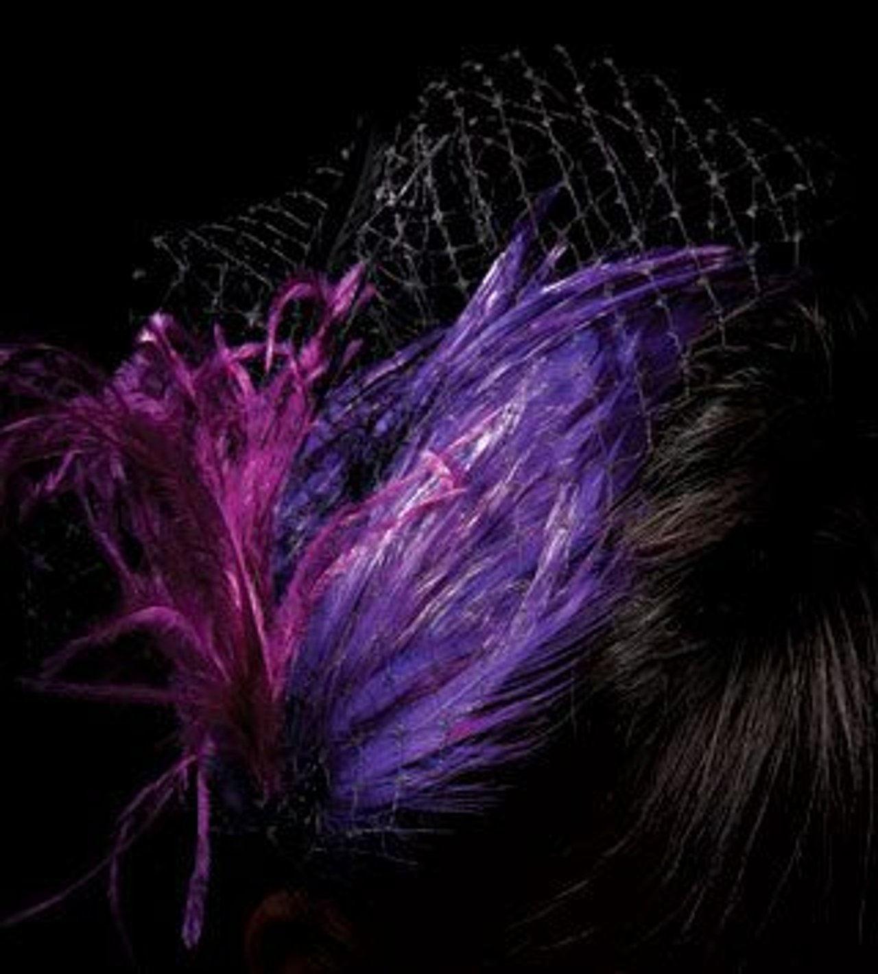 Purple feather and netting fascinator