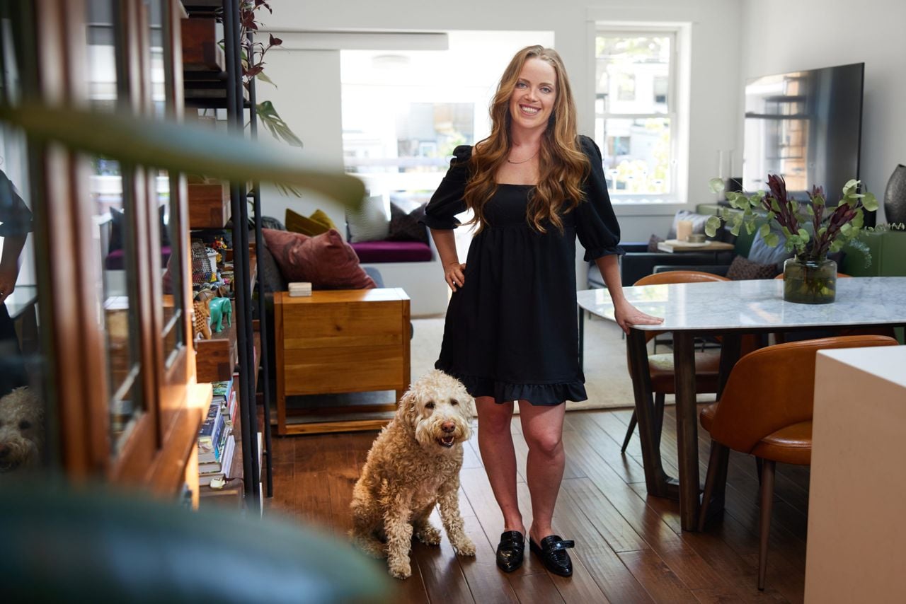 Georgia Nevison and her dog in her 600-square-foot Leslieville bungalow, which is nearly half the size of her old pad, but twice as homey