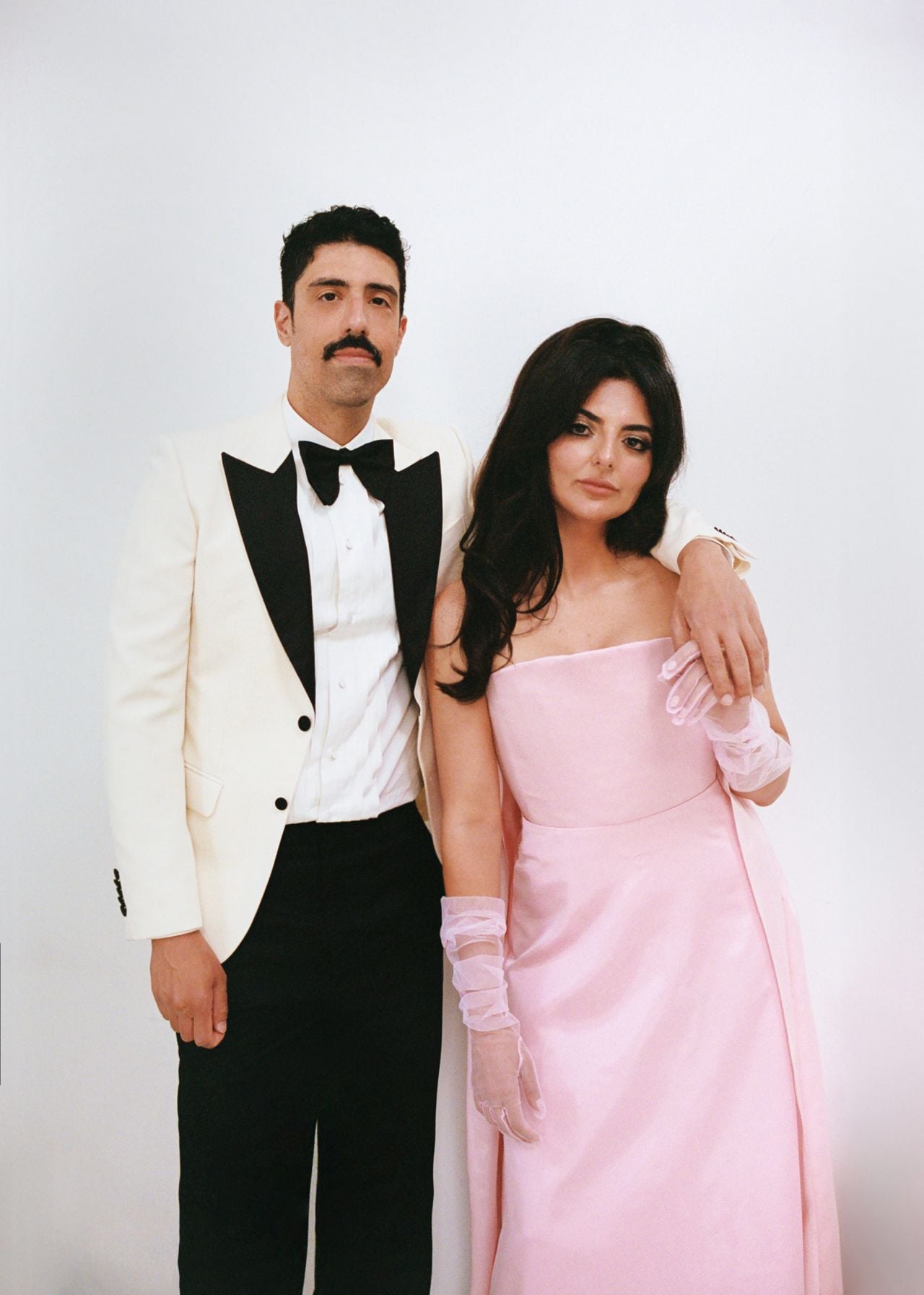 Roya and Mani posing in front of a white background