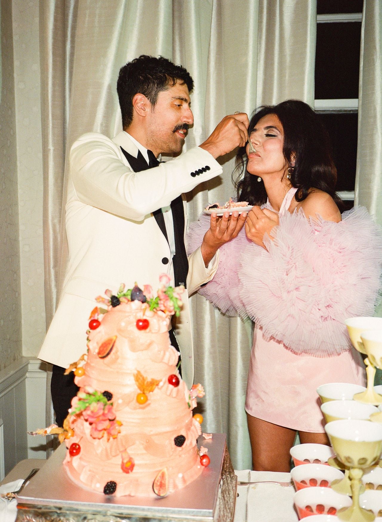 Mani feeding Roya a bite of their wedding cake