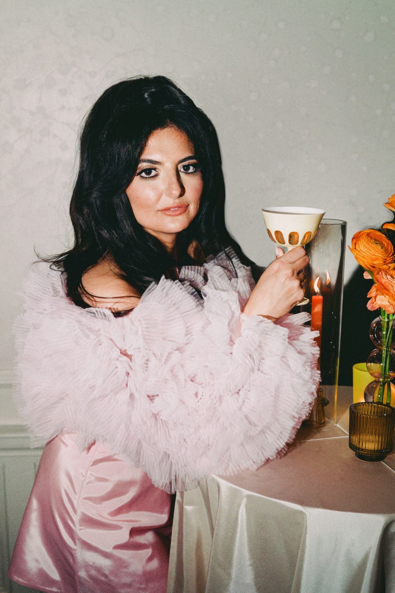Roya holding a small wine glass at her wedding reception