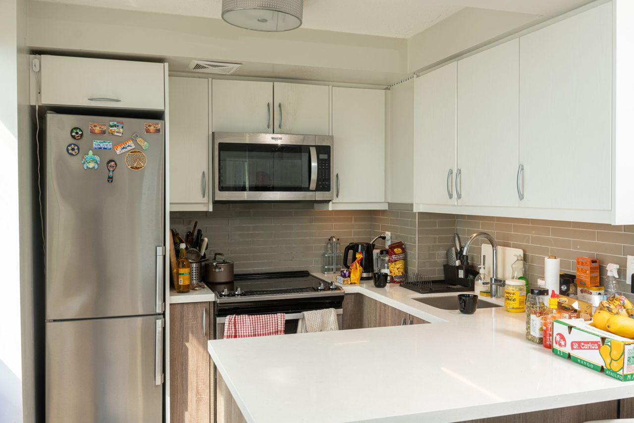 Ravneet's kitchen, which is mostly white with silver appliances