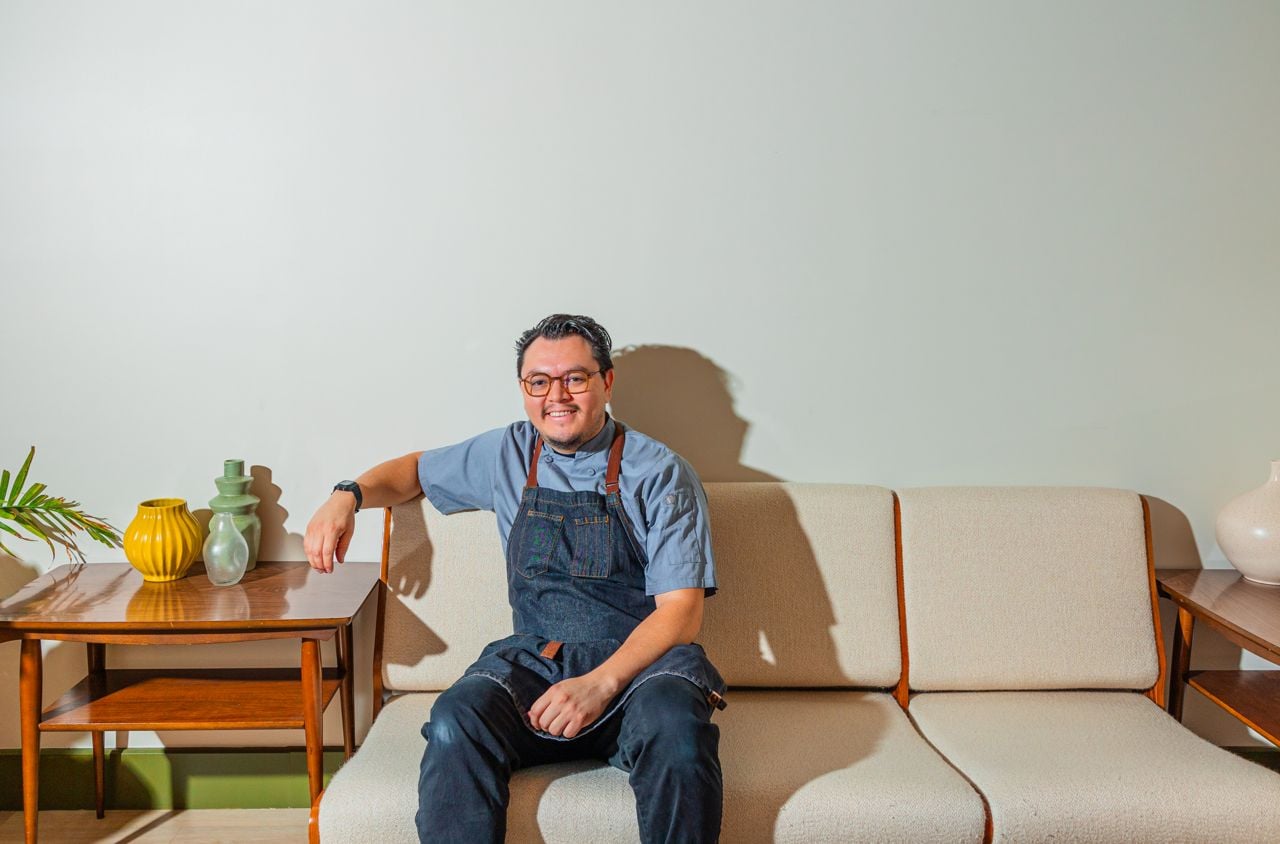 Chef Gerry Quintero sitting on an off-white couch at Ficoa
