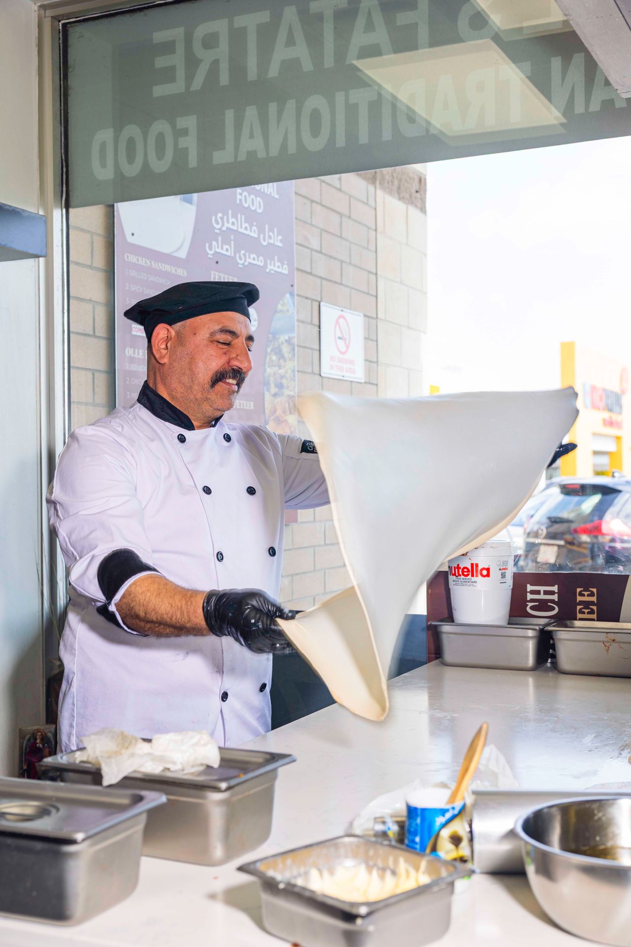 A chef tosses dough to make feteer, Egyptian pizza