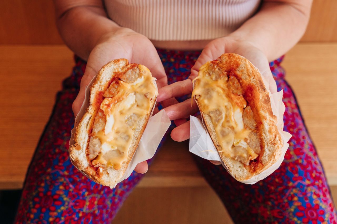 A person holds the sausage, egg and cheese breakfast sandwich at Made Rite in Toronto