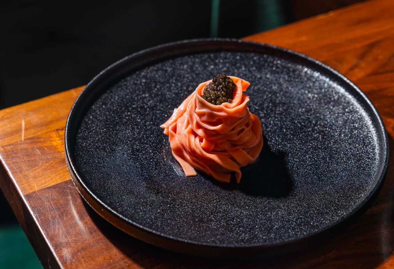 Tajarin is reimagined with beetroot dough, tossed in garum butter and crowned with smoked caviar