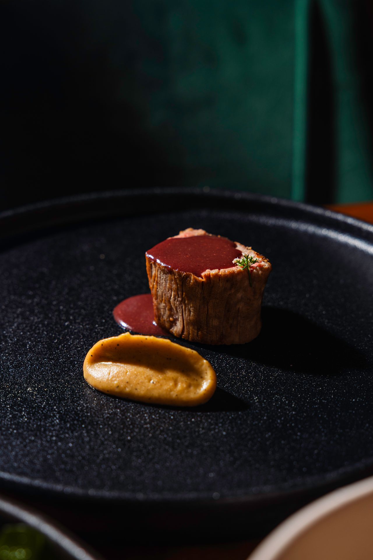 This binchotan-grilled veal tenderloin is plated with charred parsnips and a glossy jus made from tart Saskatoon berries