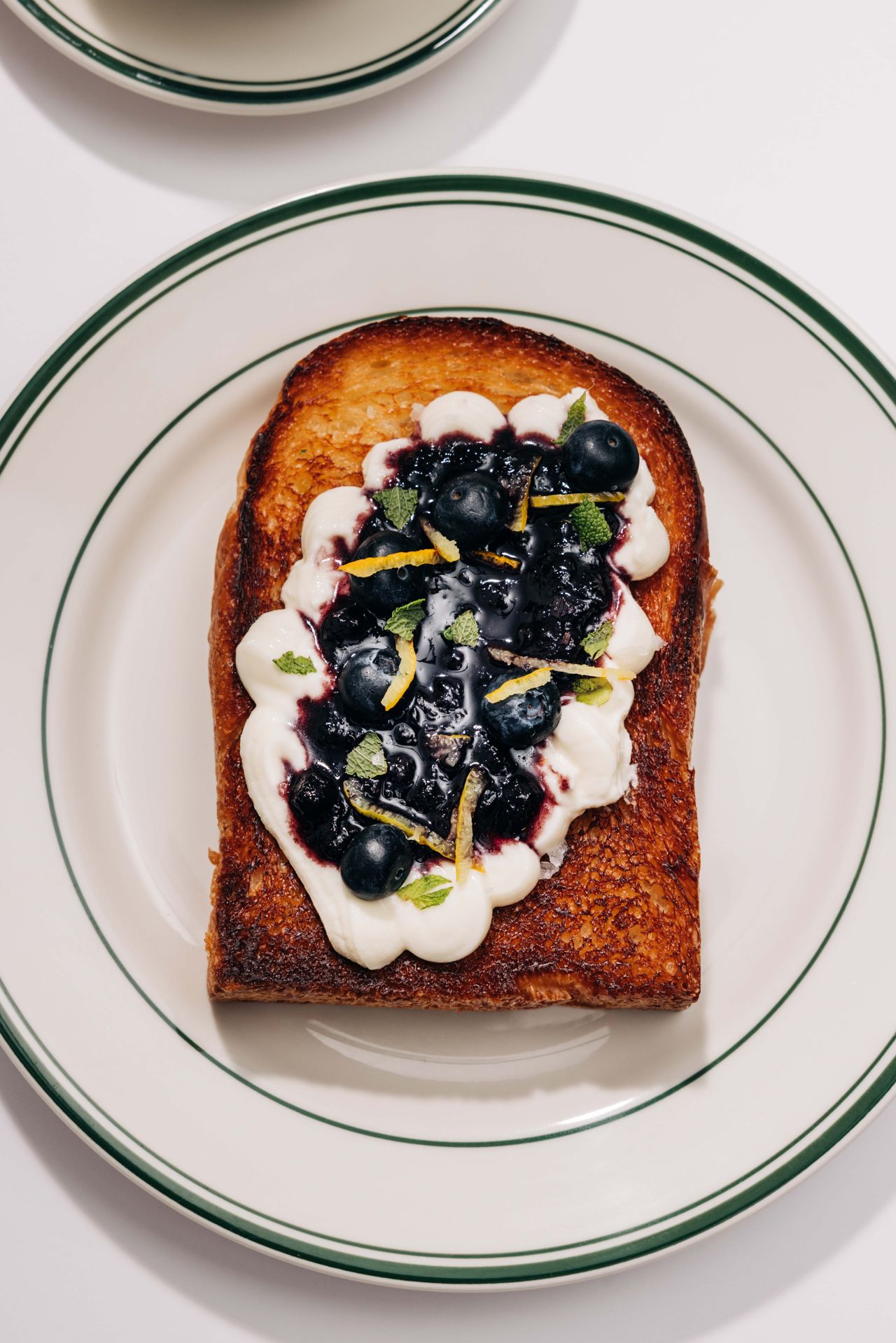 Shokupan spread with ricotta and blueberry compote, dappled with fresh blueberries and sprinkled with yuzu and mint