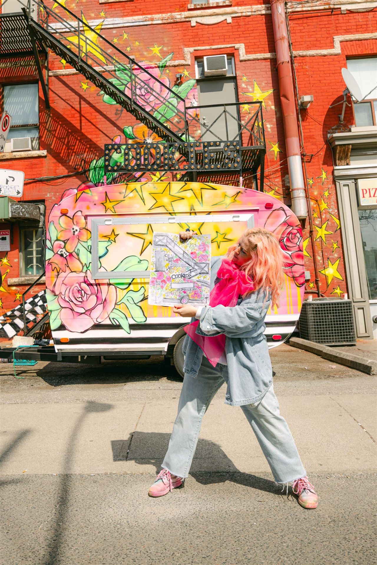 Designer Tiffany Pratt holds up a painting of her vision for Robert Street Cookies