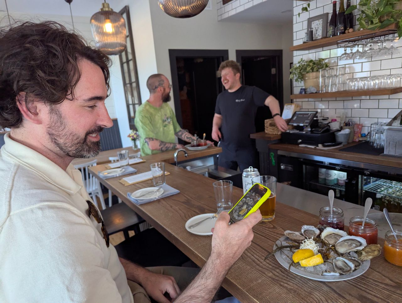 Chef Eric Robertson uses his phone to take a photo of a plate of shucked oysters