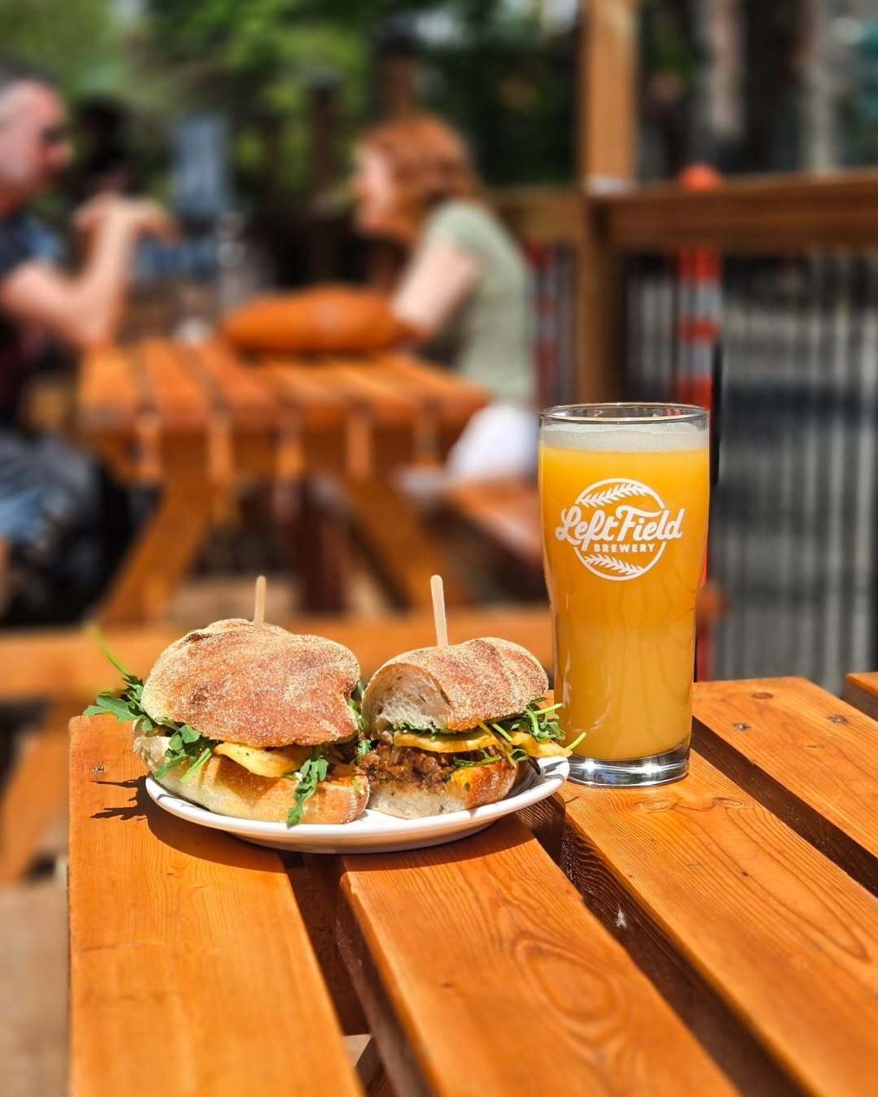 Food and a beer on a picnic table on Amber Kitchen's patio in Toronto