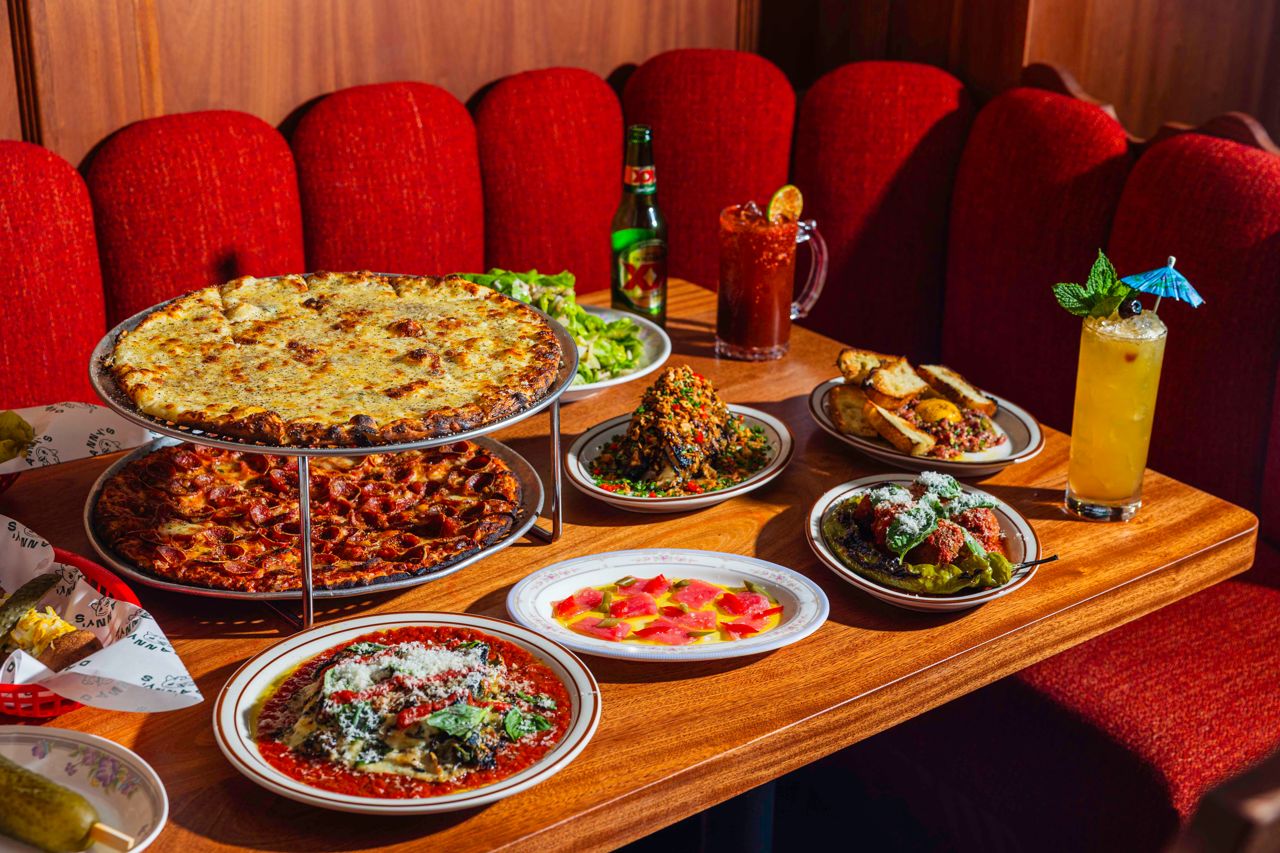 A spread of pizza, side dishes and drinks at Danny's Next Door