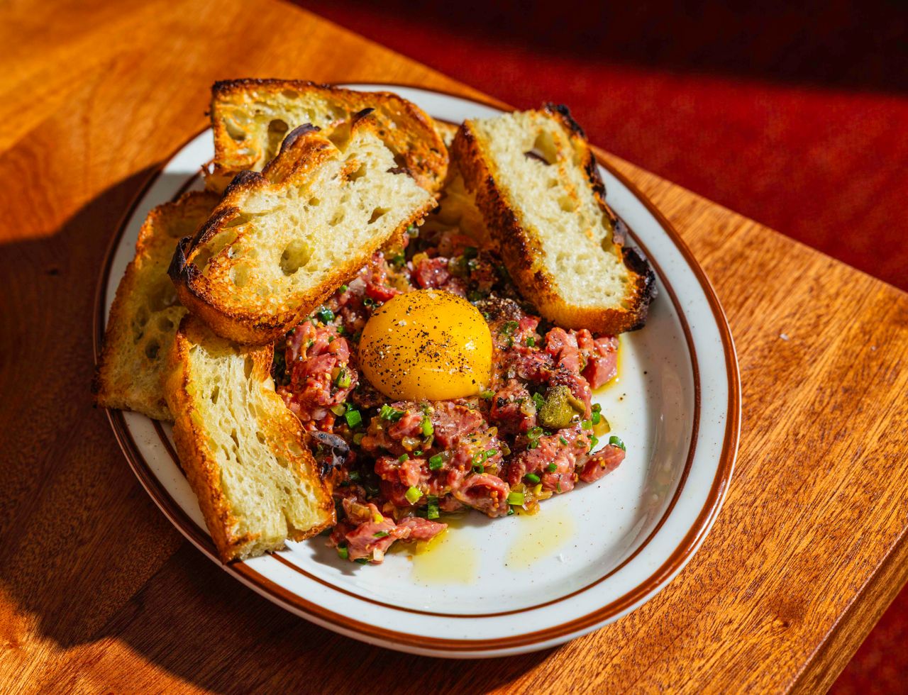 The uber-traditional French tartare is a blend of chopped tenderloin, pickles capers, shallots, parley and mustard vinaigrette, topped with an egg yolk and served with toasted focaccia