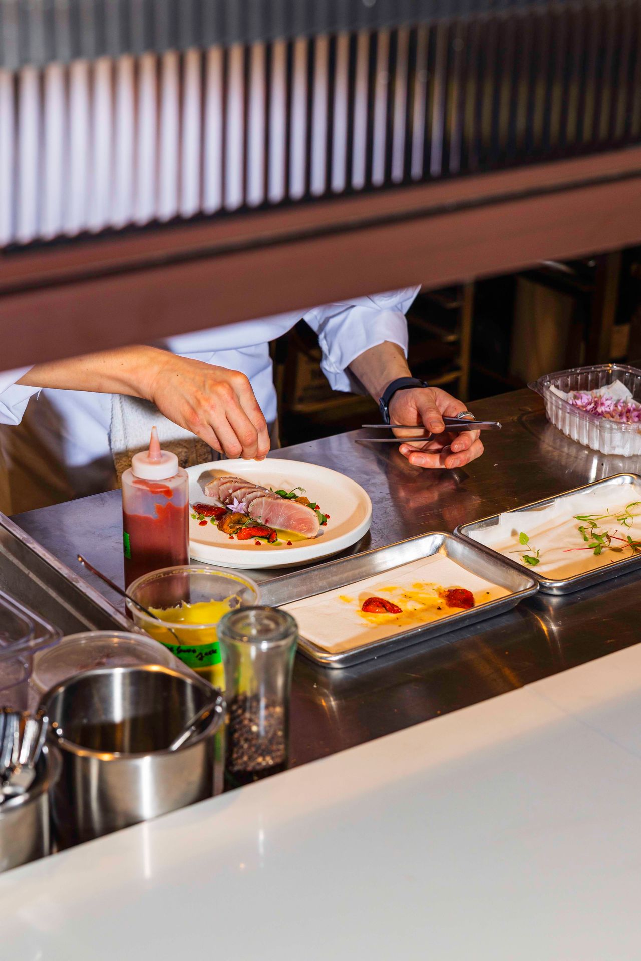 A chef preps a cured and smoked amberjack dish