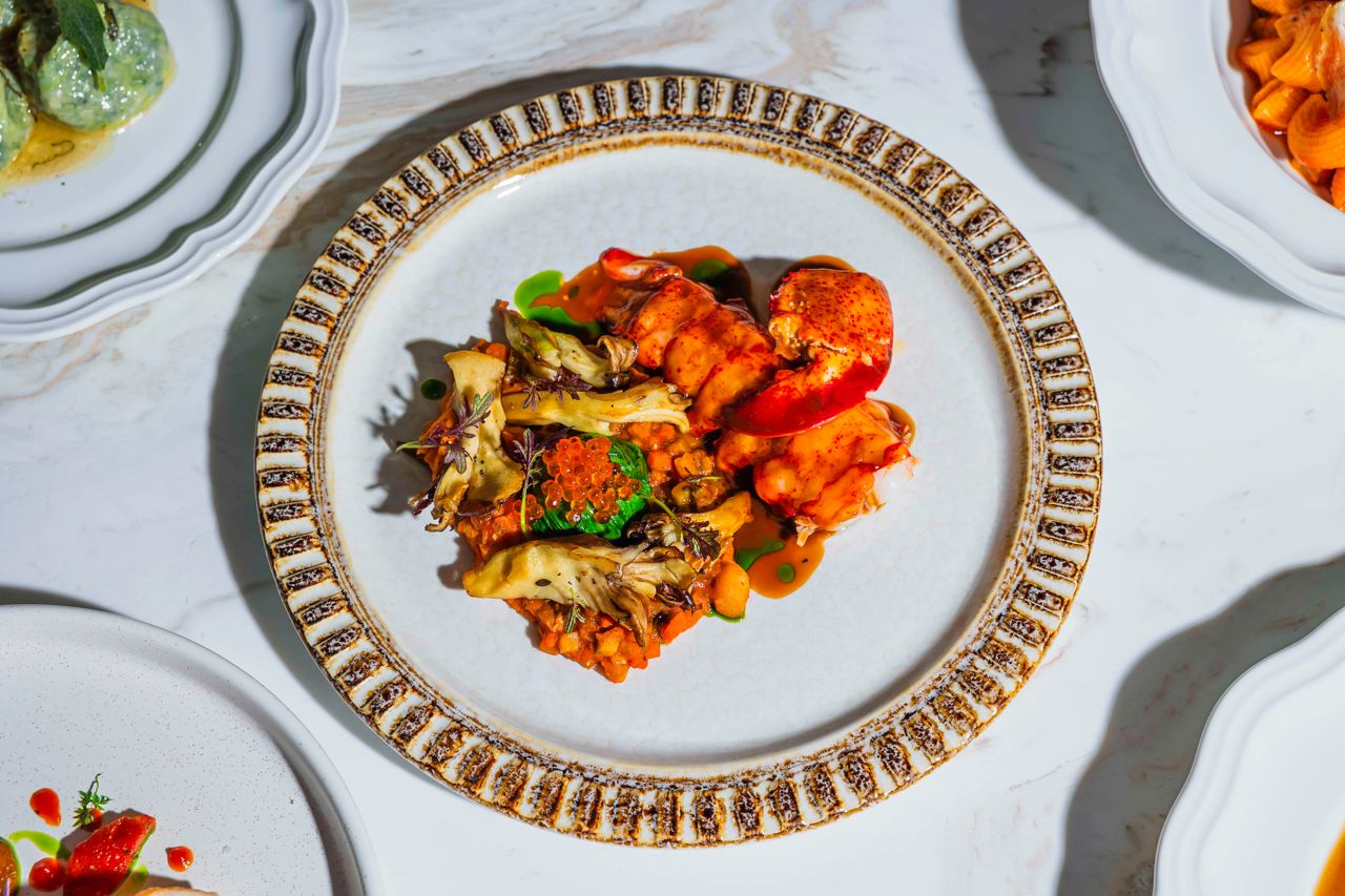 A one-and-a-half-pound Nova Scotian crustacean arrives, showcasing its tail and a single hulking claw, and served over a brothy cannellini bean ragu with seared blue oyster mushrooms