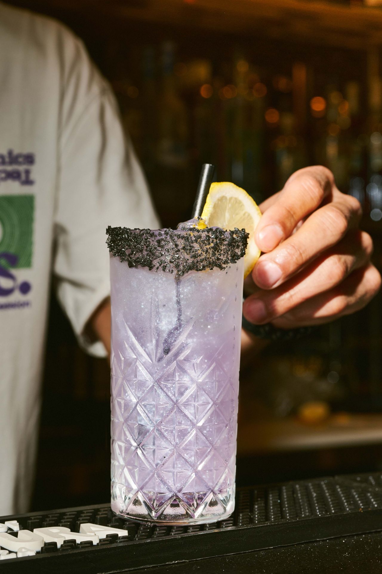 This is the Likkle Lavender, a blend of Ketel One vodka and lime with Prosyro lavender syrup and B’Lure flower extract, topped off with club soda and finished with edible glitter