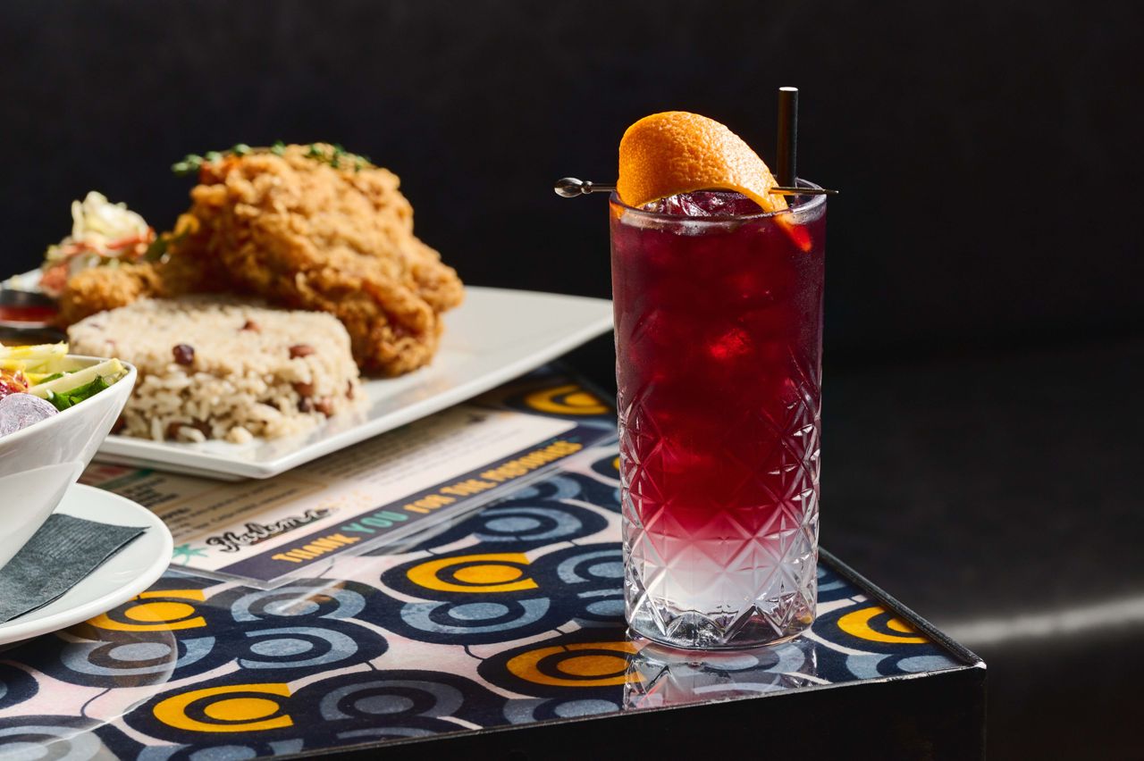 The Kingston is a rum-based cocktail with almond syrup and lime on the bottom, and a red wine float