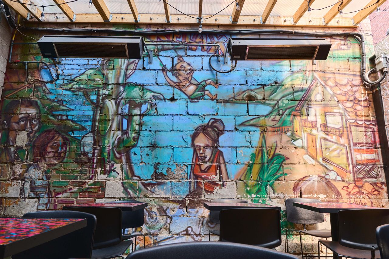 Graffiti art decorates a brick wall of the patio at Harlem Restaurant