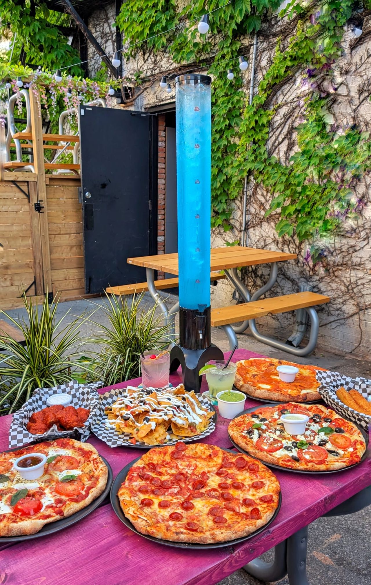 A spread of pizzas and a margarita tower at Little Ese in Toronto
