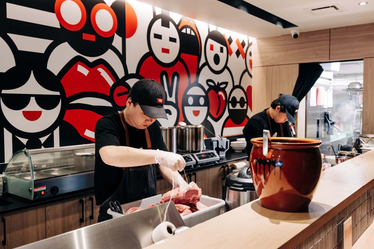 Chefs work behind the counter at Ramen Tabetai in Toronto