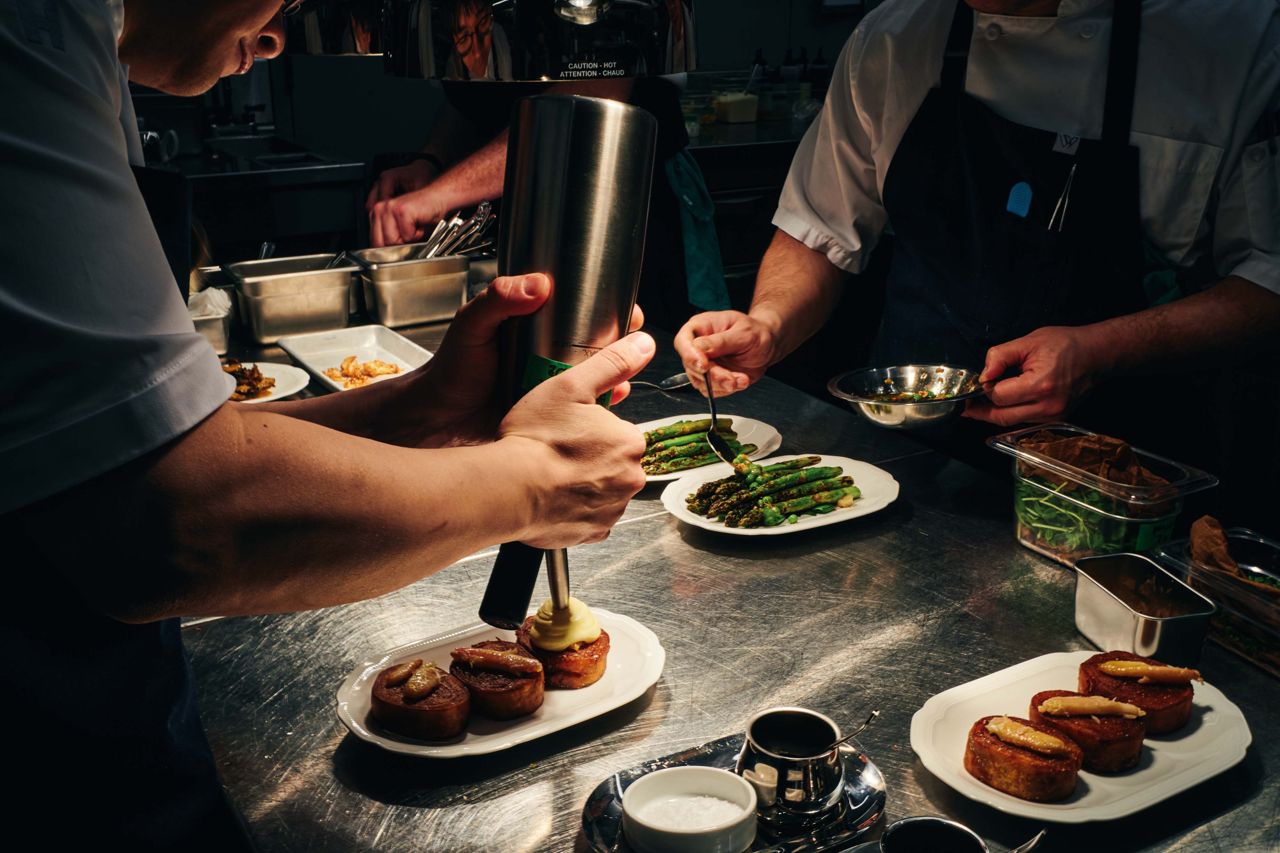 Chefs put the finishing touches on dishes in a restaurant kitchen