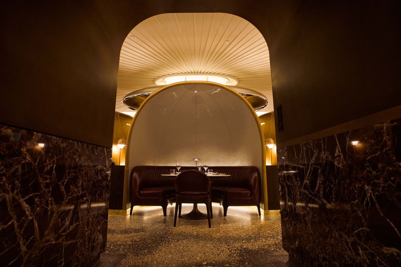 Semi-private dining pods curve beneath a ceiling dome, offering both privacy and a sense of spectacle at the centre of the room