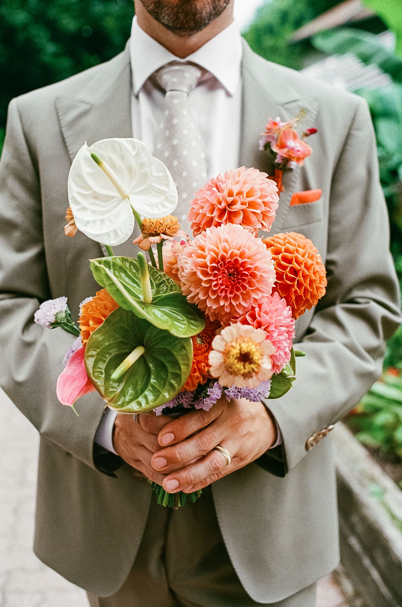 Zach holding a bouquet of flowers at his wedding