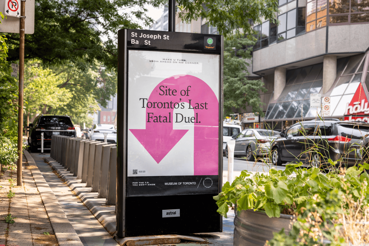 A bus shelter advertisement reading "Site of Toronto's Last Fatal Duel"