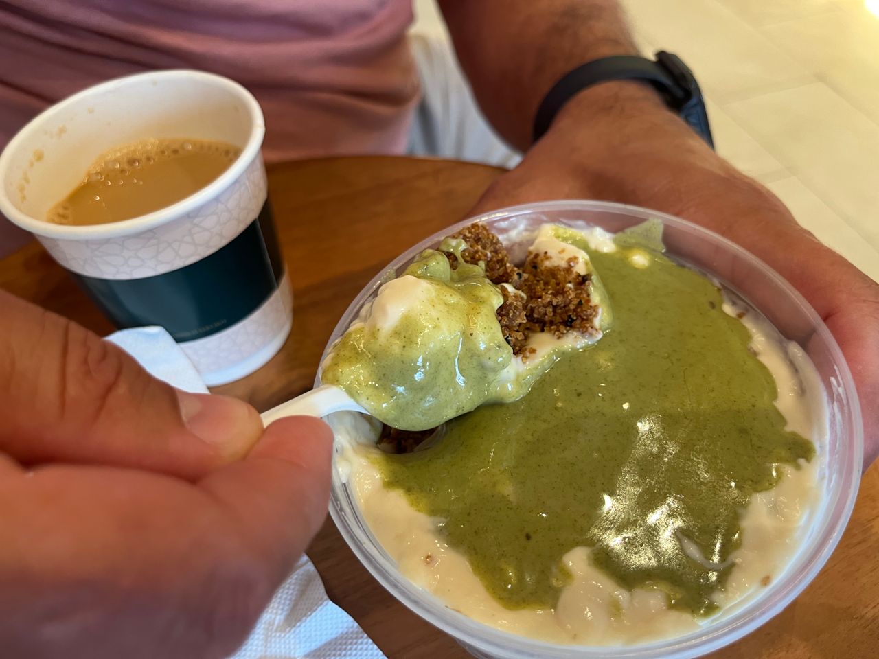 A person uses a spoon to eat pistachio areeka