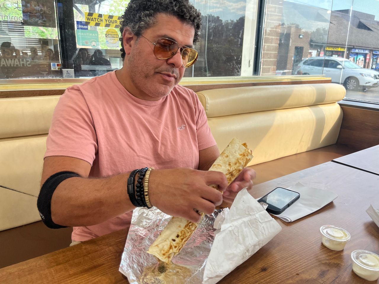 Chef Nizar El Ali holds a large chicken shawarma wrap