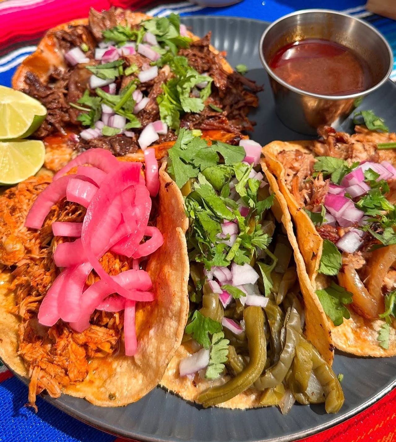A trio of tacos with salsa