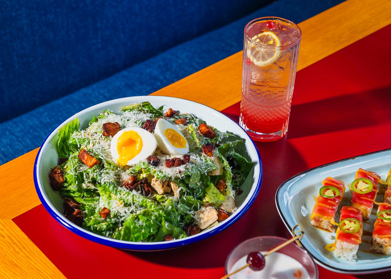 A caesar salad with chicken and a hard-boiled egg
