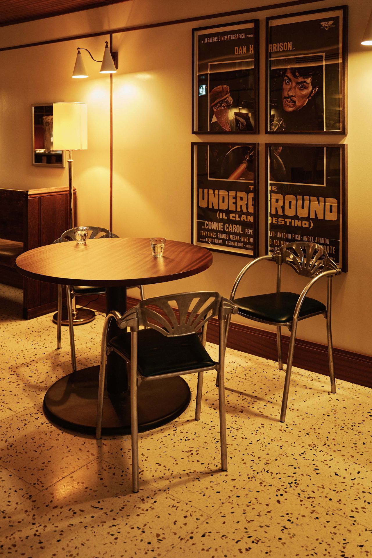 A table for three next to vintage Italian movie posters in the dining room of NL Ginzburg in Toronto