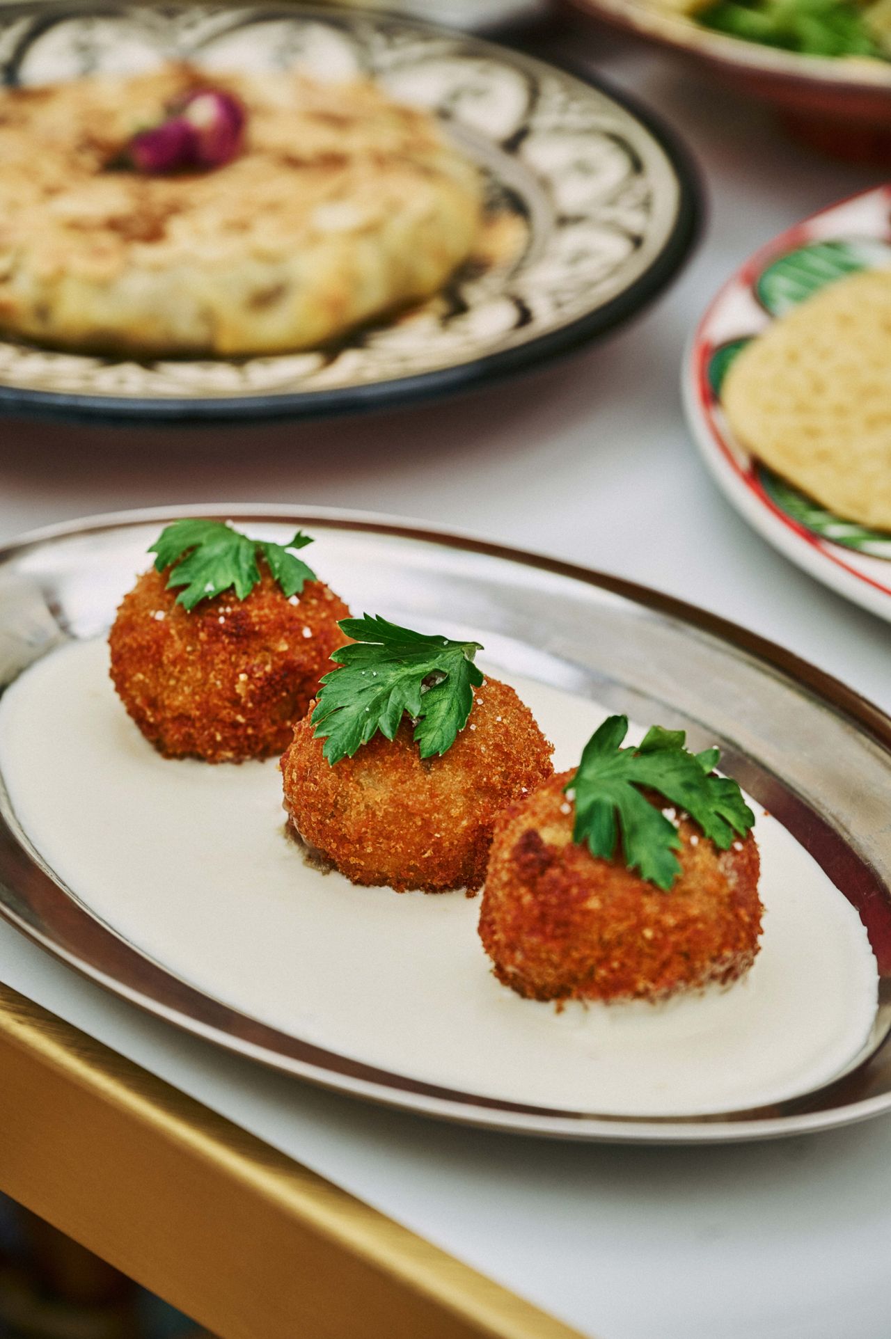 These are maakouda, golden-fried potato balls filled with cheese and seasoned with shallot, cilantro and nutmeg