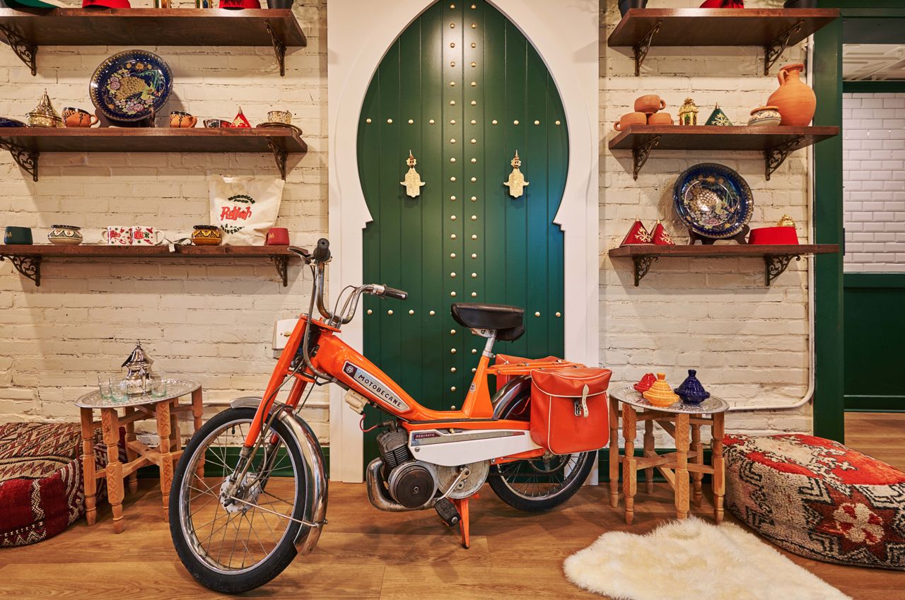 The dining room at Rayah is decorated with Moroccan poufs, textiles, pottery and a bicycle