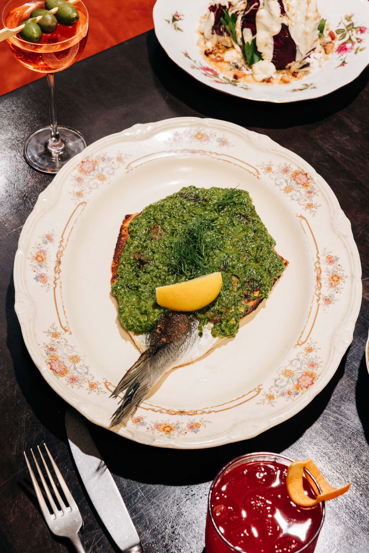 This whole butterflied branzino, crisped on the flat-top, comes blanketed in punchy salsa verde and finished with fennel fronds