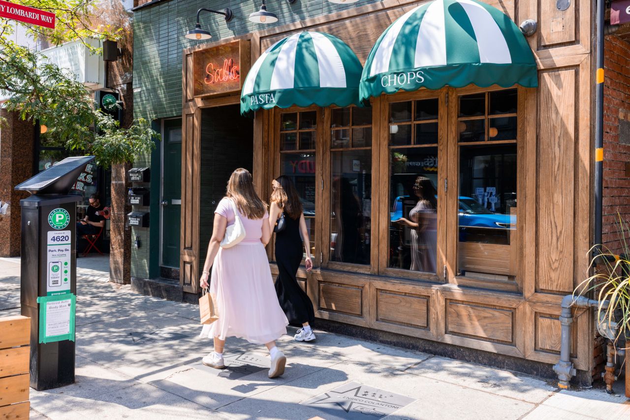 Two women walk past Sal's Pasta and Chops