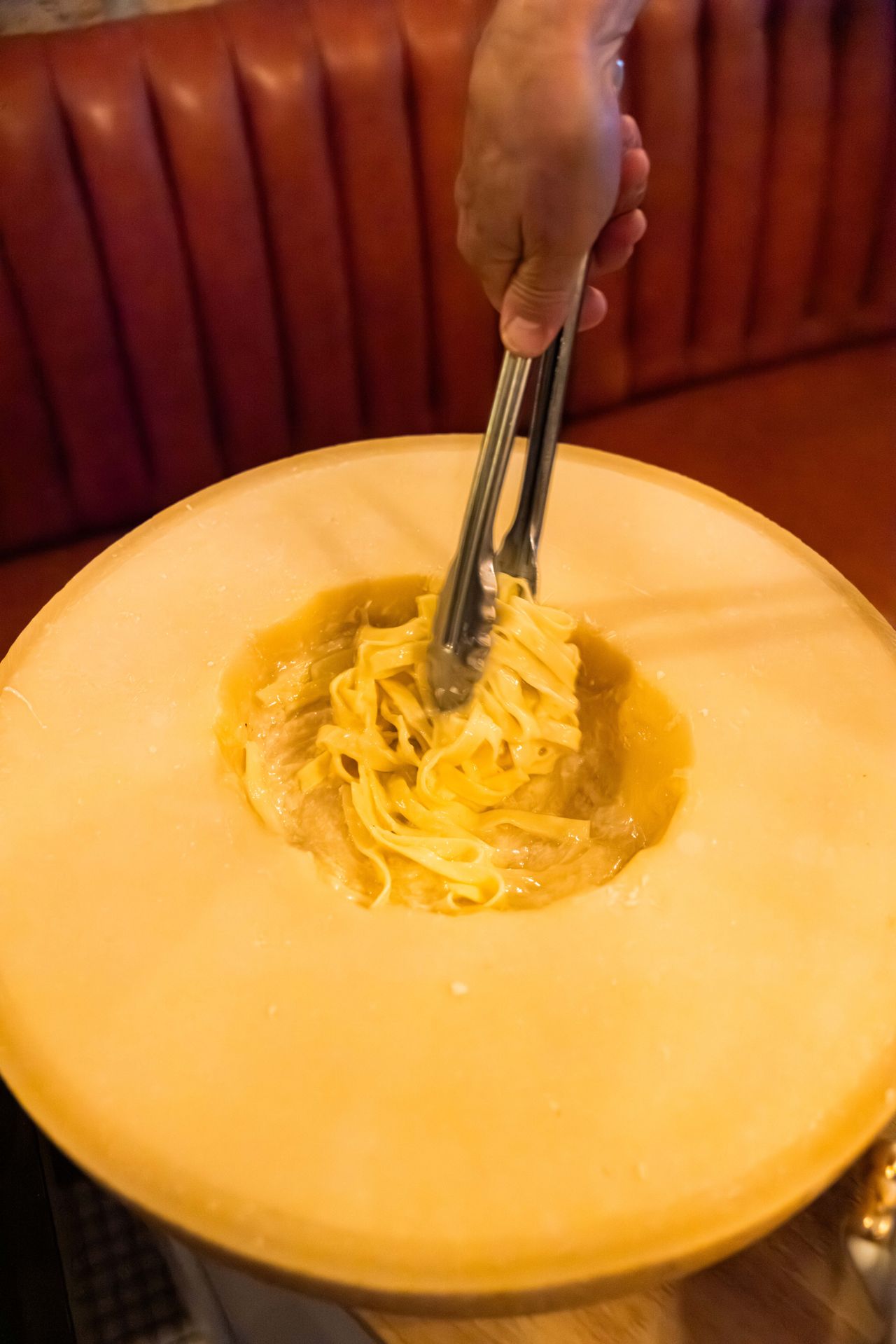 The handmade tagliatelle, tossed tableside in the wheel, absorbs the molten cheese and flame-kissed richness