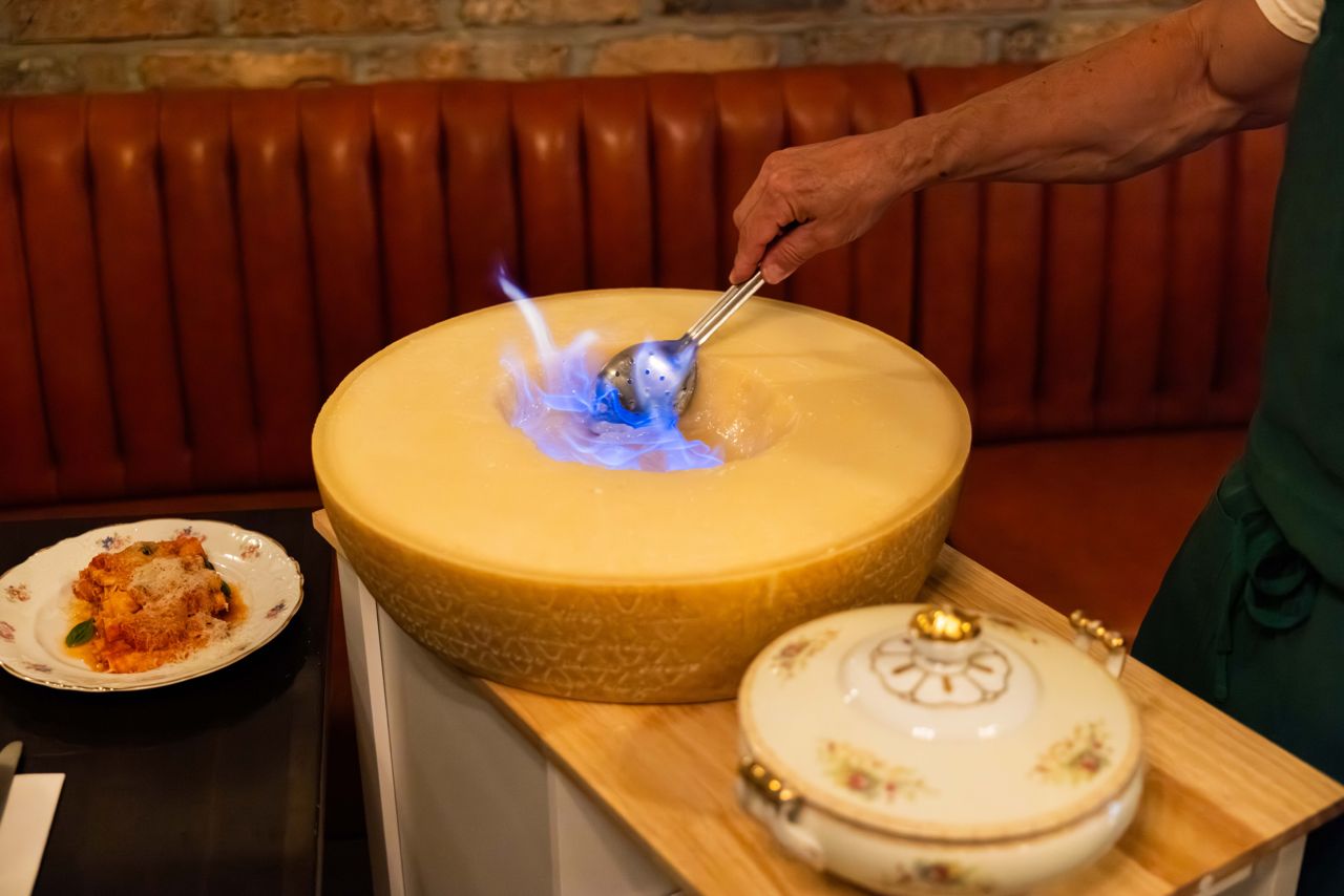 For the Tagliatelle alla Parm Wheel, the interior of a hollowed Parmigiano-Reggiano wheel is set ablaze, melting the cheese into a creamy base for the pasta