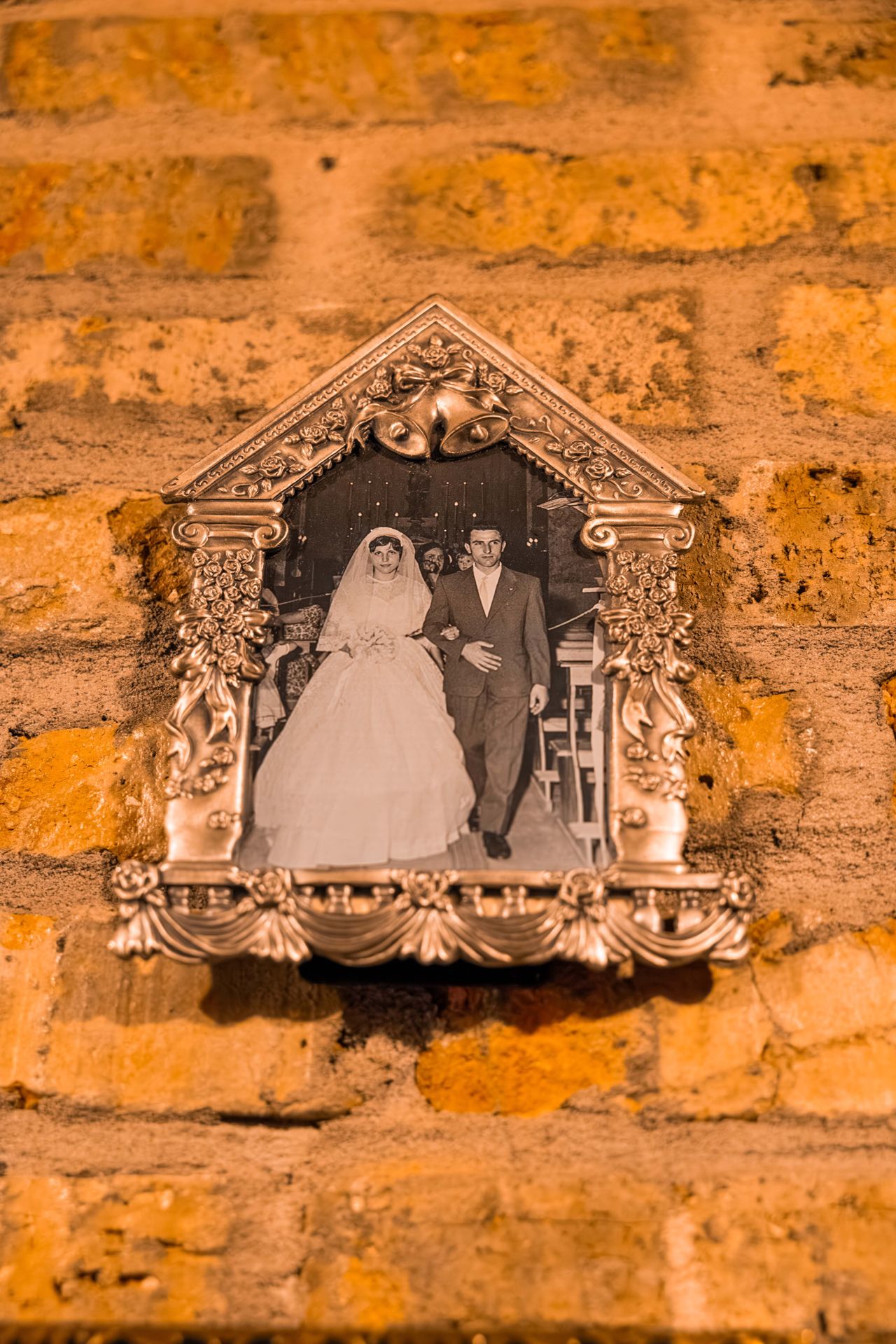 An old family photo hangs on a brick wall