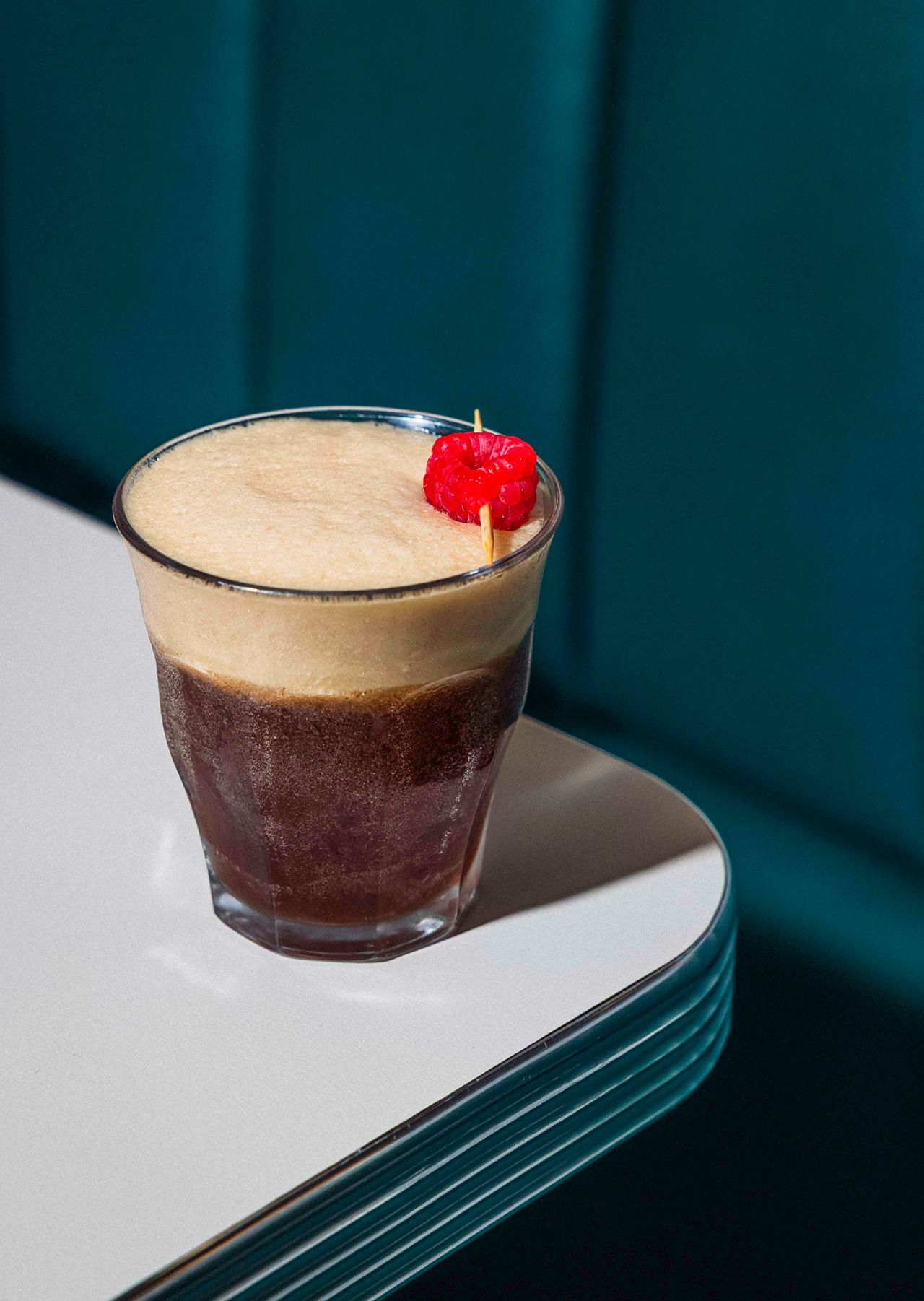 A Coke float garnished with a raspberry
