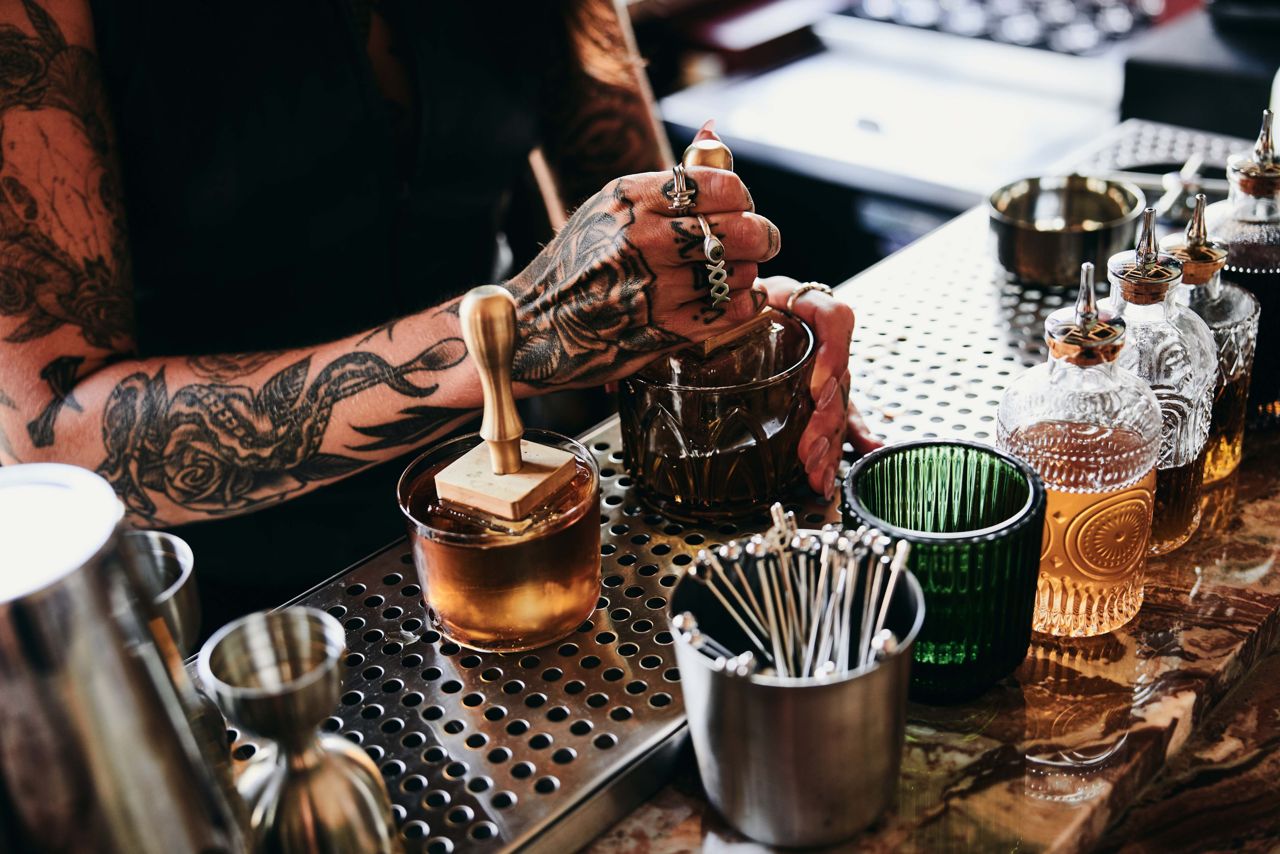 A bartender stamps an ice cube