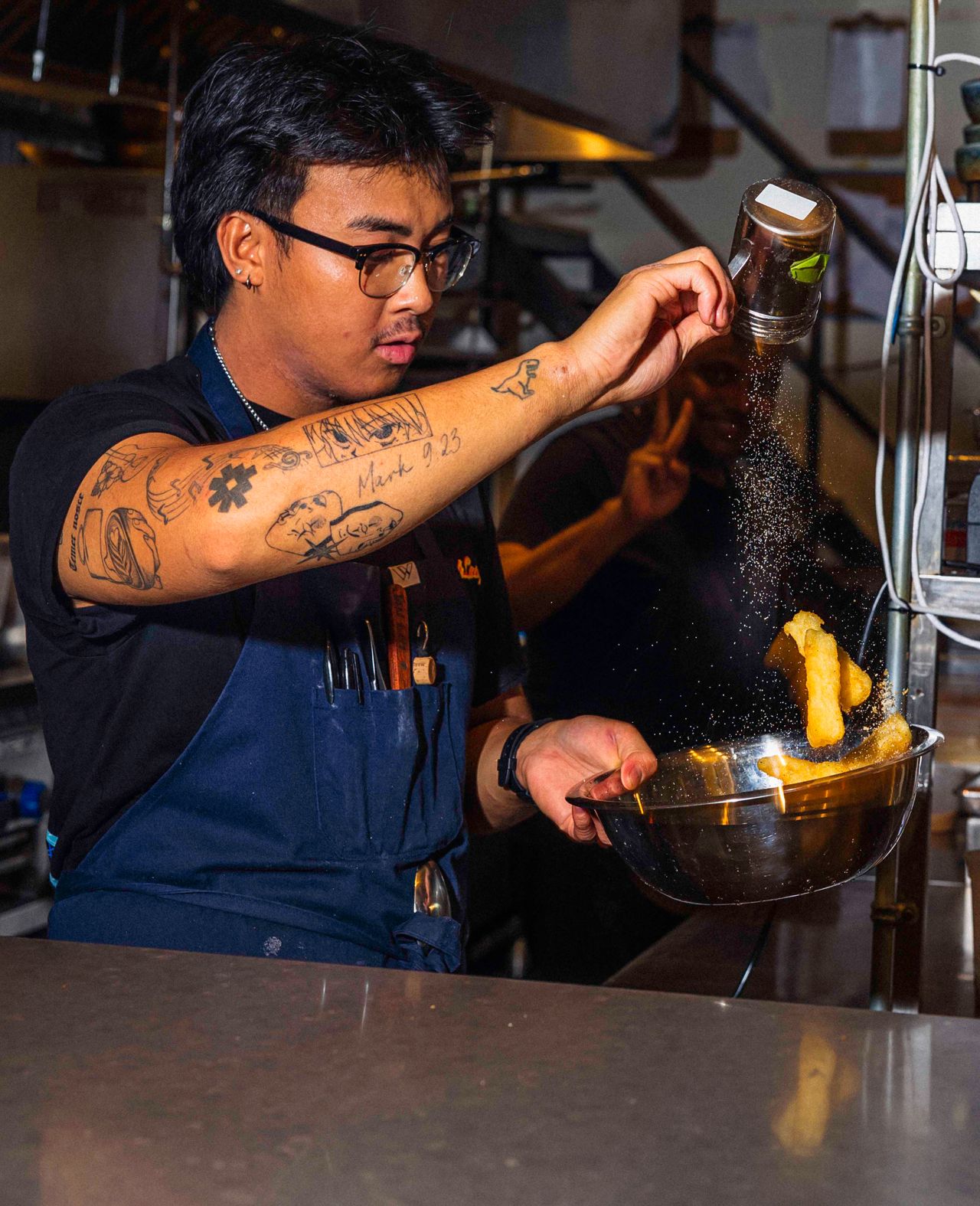 A chef salts cassava fries