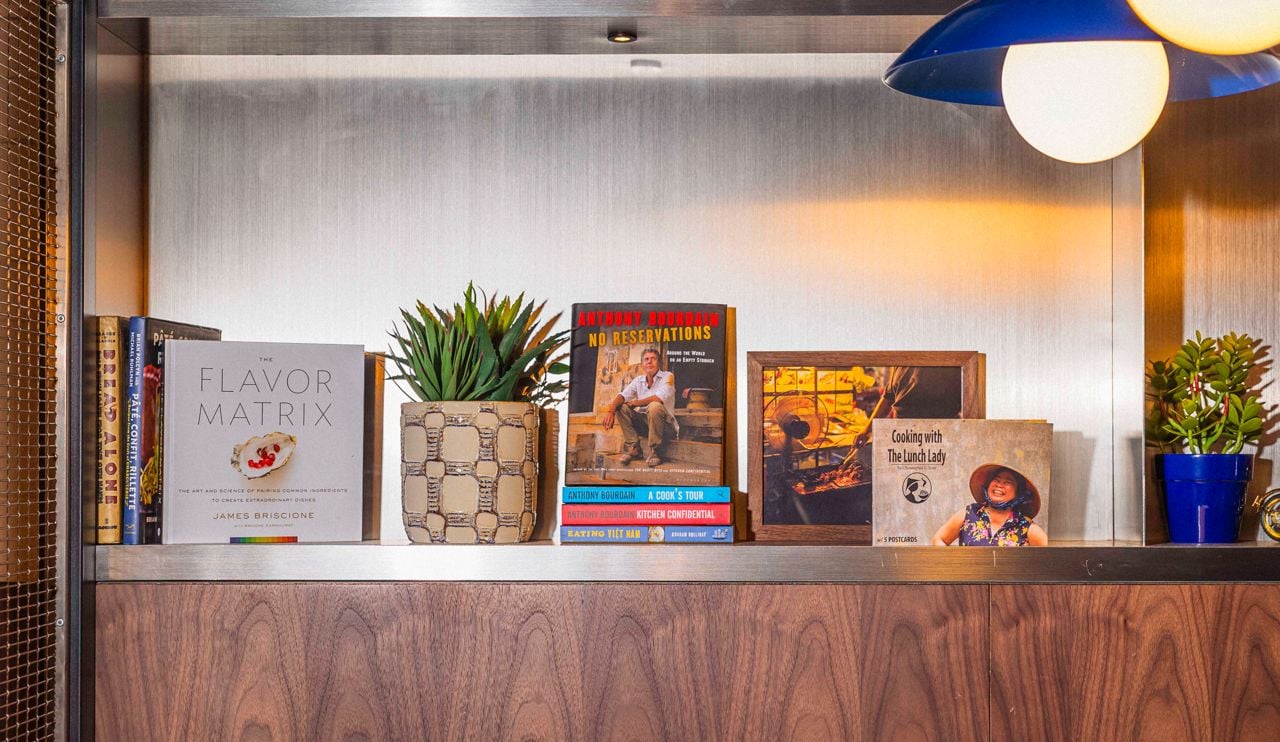A shelf lined with books and plants at the Lunch Lady