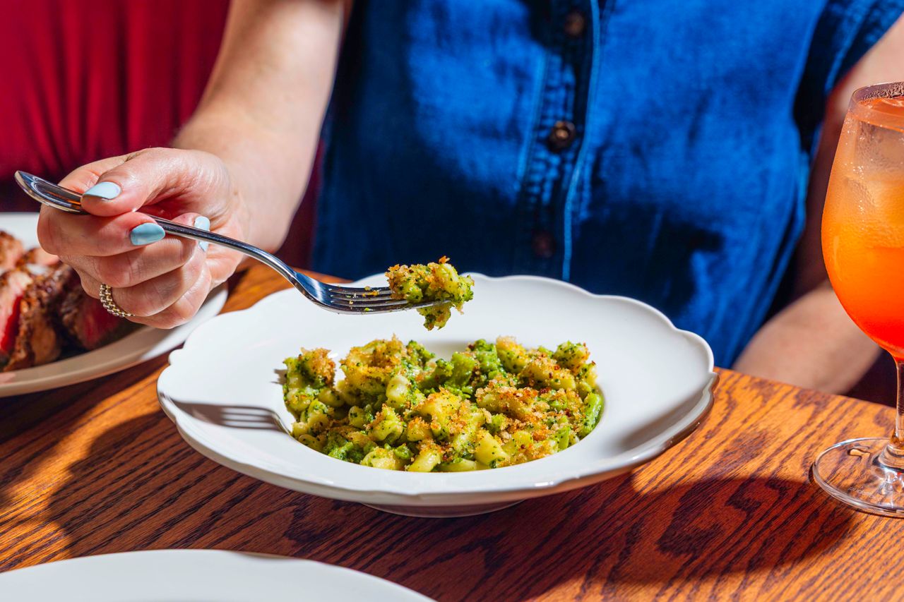 A person eats a bowl of cavatelli