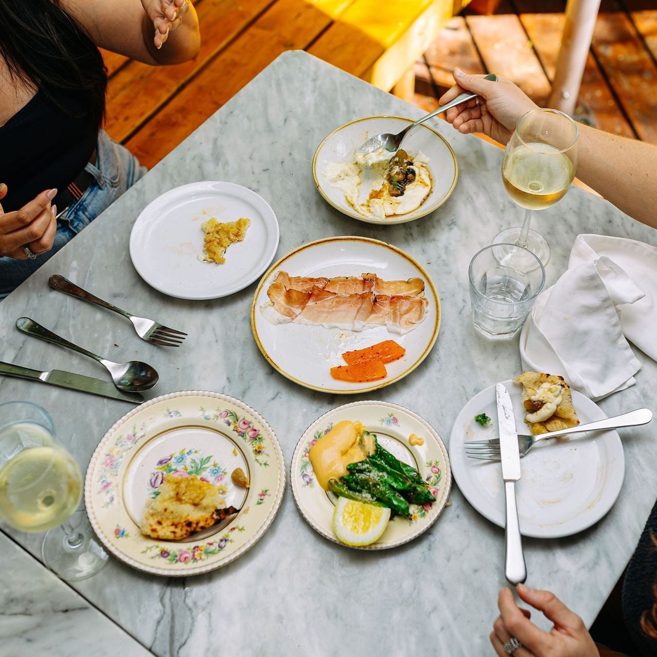 People sit at a table set with snacks and drinks during Viaggio's aperitivo hour