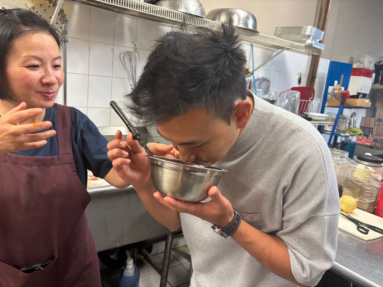 Chef Vicky Cheng smells oxtail sauce in a bowl at Allwyn's Bakery