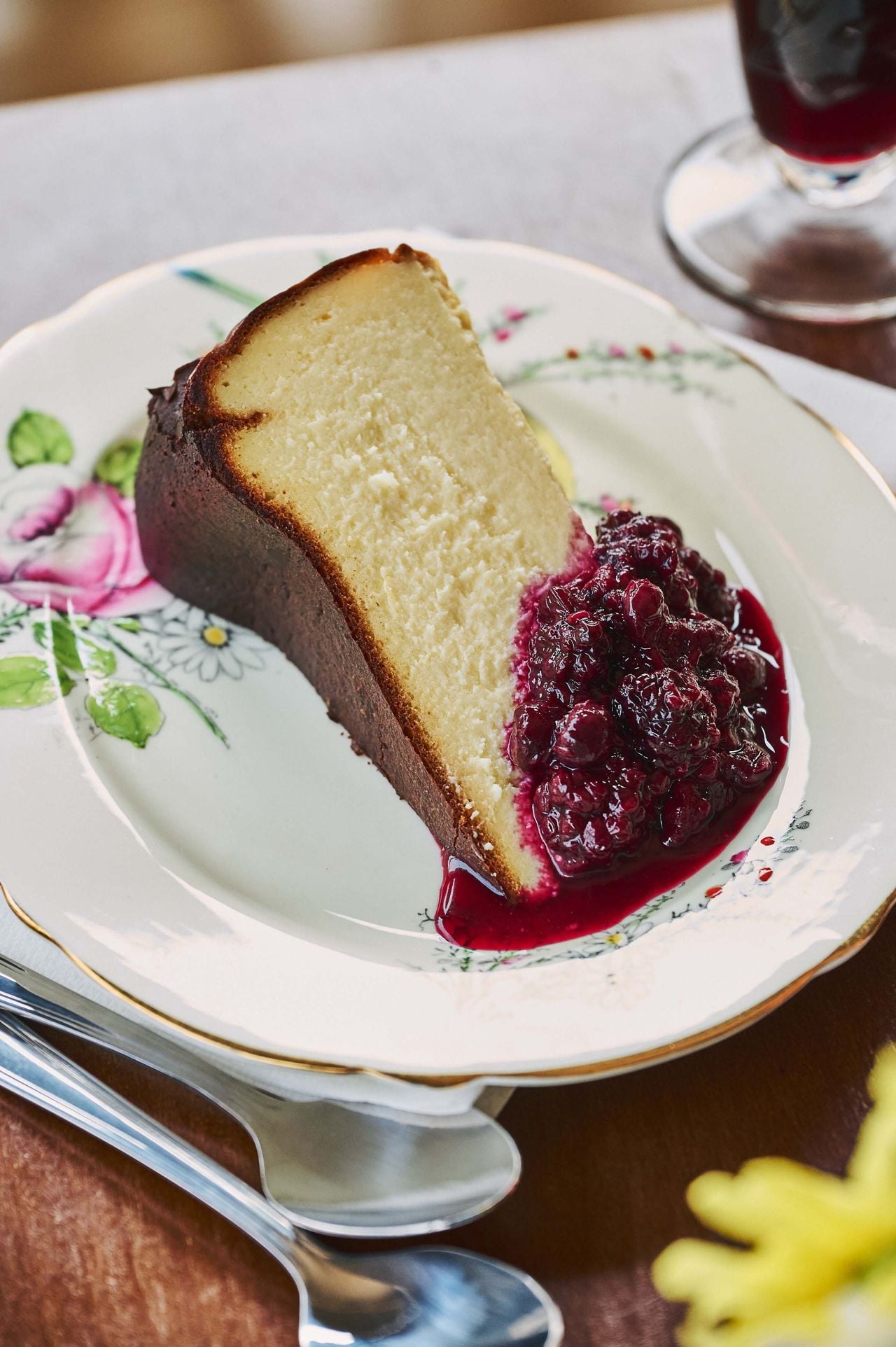 A slice of crustless Basque cheesecake with berry compote