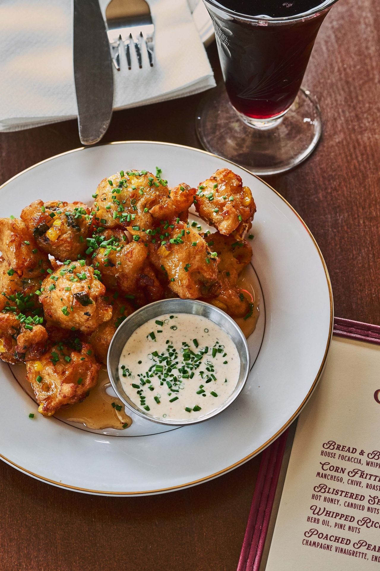 The crunchy corn fritters are a combination of fresh grilled corn, roasted poblanos, manchego and a gluten-free batter. They’re fried until flaxen, drizzled with hot honey and finished with chives. House ranch dressing comes on the side for dunking