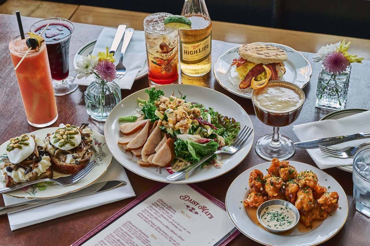 A spread of dishes and drinks at Daisy May's, a diner